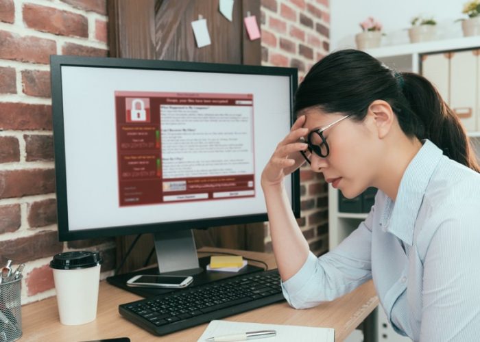 tristeza, agente de la empresa, mujer que encuentra una computadora que trabaja y que está chantajeando. El ataque contra el virus piensa en una solución en el escritorio de la oficina y siente depresión.