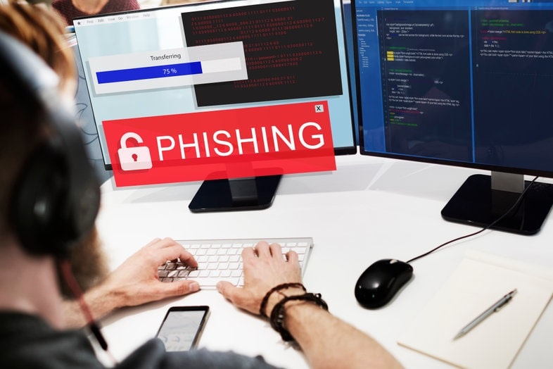 una persona delante de un ordenador realizando un ataque cibernético de phishing