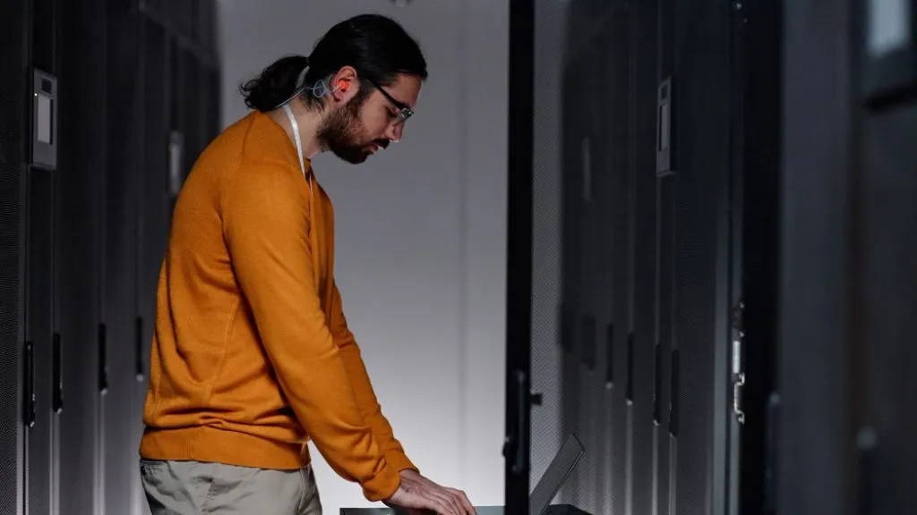 Técnico de TI configurando un servidor NAS en un centro de datos profesional.
