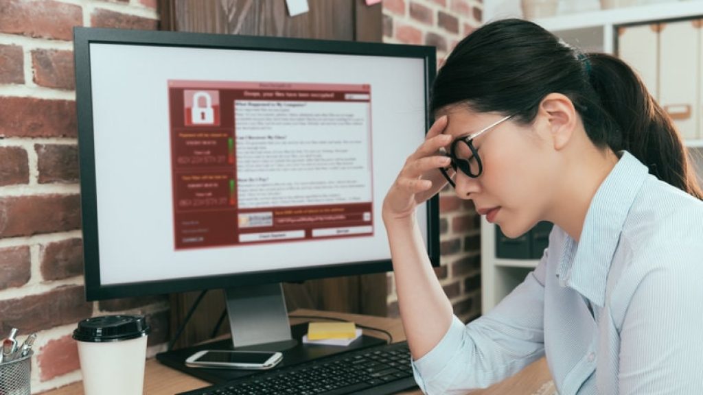 tristeza, agente de la empresa, mujer que encuentra una computadora que trabaja y que está chantajeando. El ataque contra el virus piensa en una solución en el escritorio de la oficina y siente depresión.